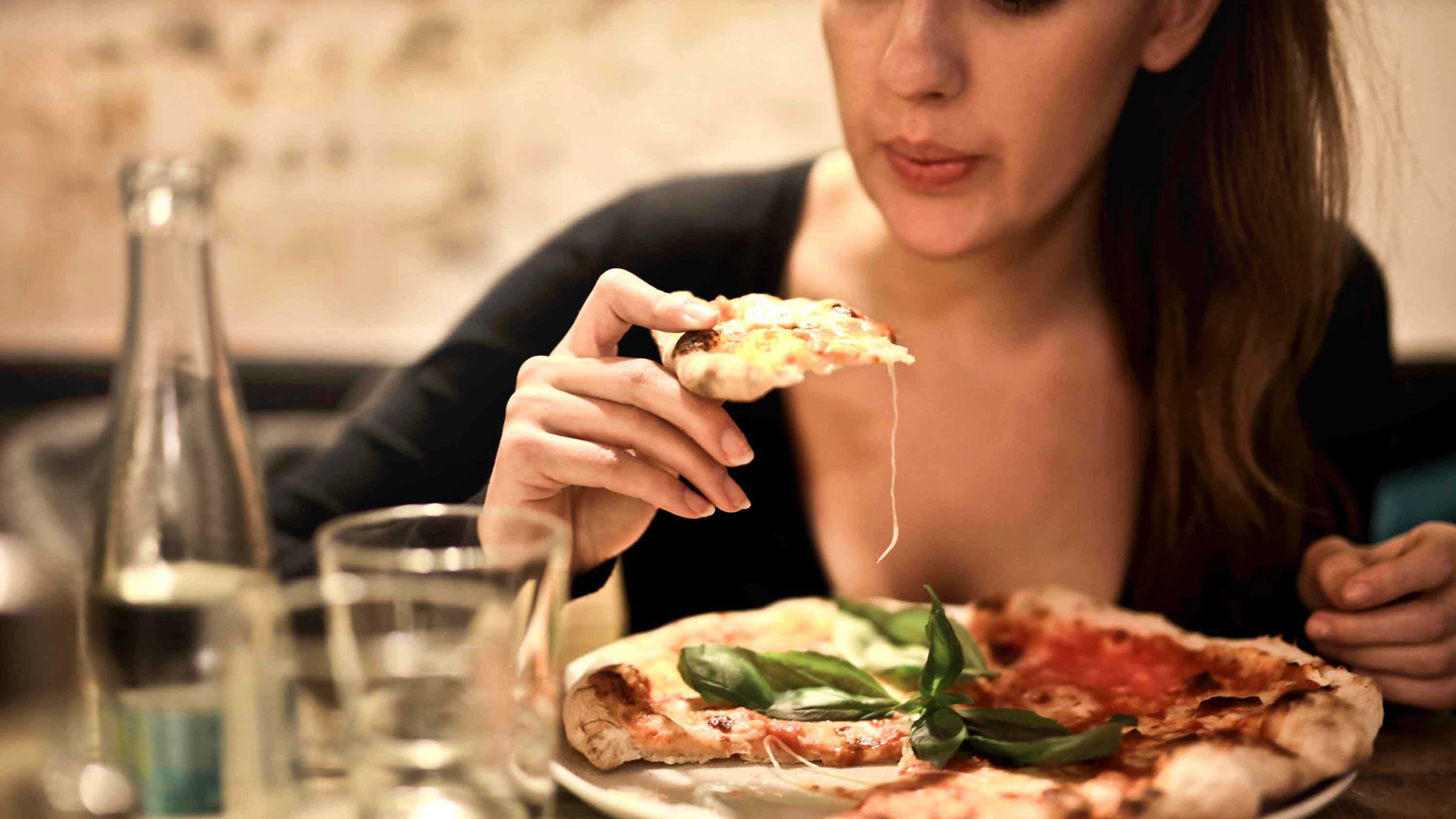 Люди едят людей название. Сытость. Не переедать. Женщина ест в ресторане вид сбоку. Самая популярная пиццерия в мире.